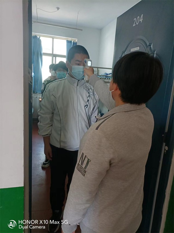 10 宿管老师为学生测量体温.jpg